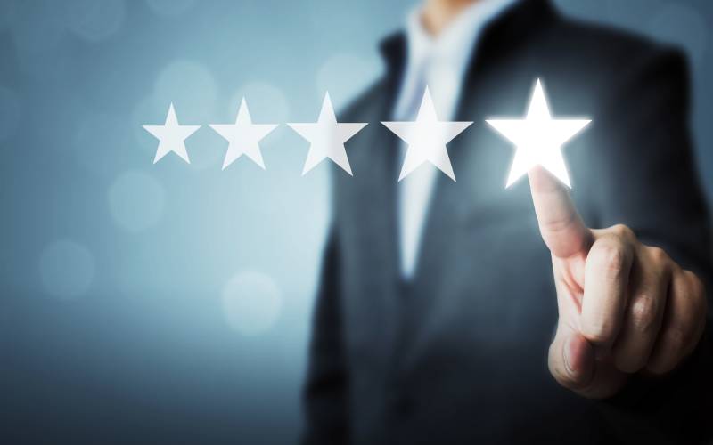 Businessman pointing five star symbol to increase rating of company